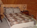 Bedroom on upper level features sliding glass doors to deck with view of golf course. TV with directv.