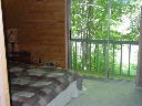 Bedroom on upper level features sliding glass doors to deck with view of golf course. TV with directv.
