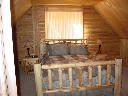 Master bedroom on upper level. Log furniture and TV with Directv.