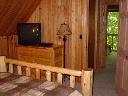 Master bedroom on upper level. Log furniture and TV with Directv.